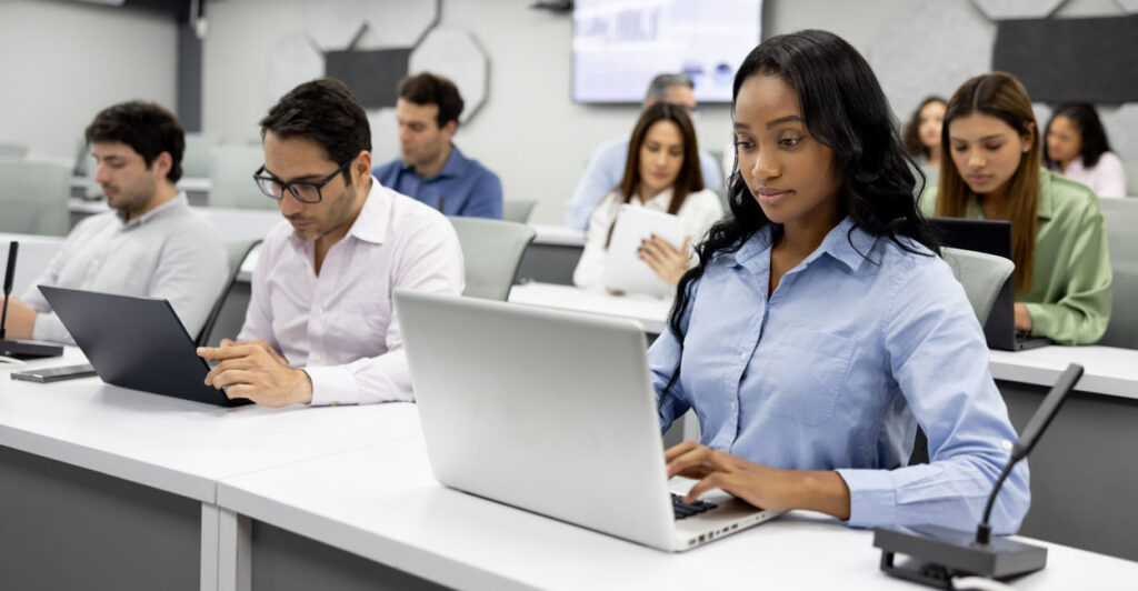 college students sitting in a lecture room on their laptops