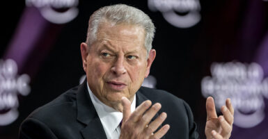 Al Bore in a black suit gestures