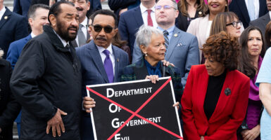 House Democrats stand with a sign reading "Department of Government Evil."