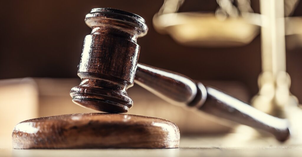 A judge's gavels is placed against a sounding block.