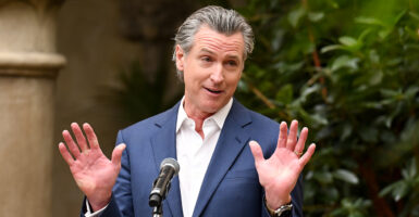 Gavin Newsom in a blue suit shrugs