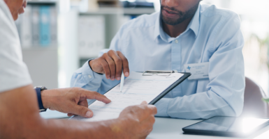 Doctor helps patient fill out paperwork.