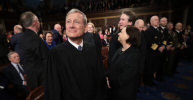 John Roberts stands wearing his black robe.