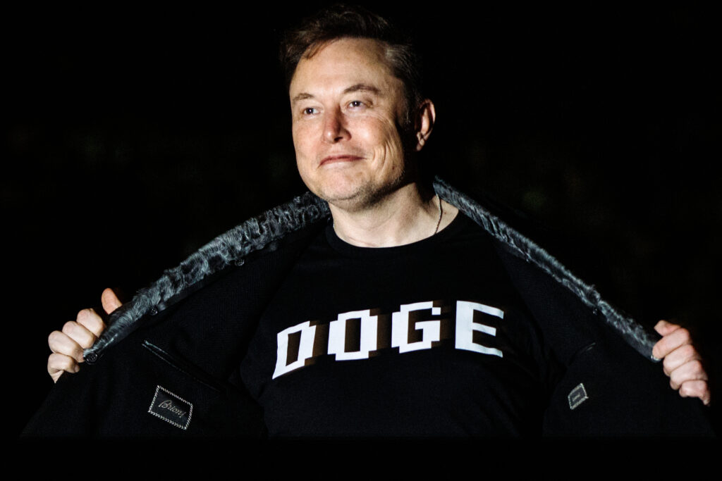 Elon Musk wears a garment sporting the acronym "DOGE" for the Department of Government Efficiency