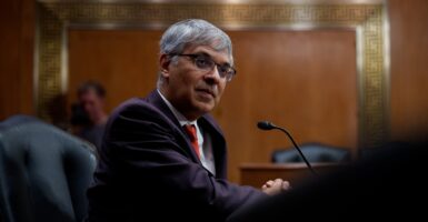 Jayanta Bhattacharya looks to his right while sitting down as he testifies before a hearing.