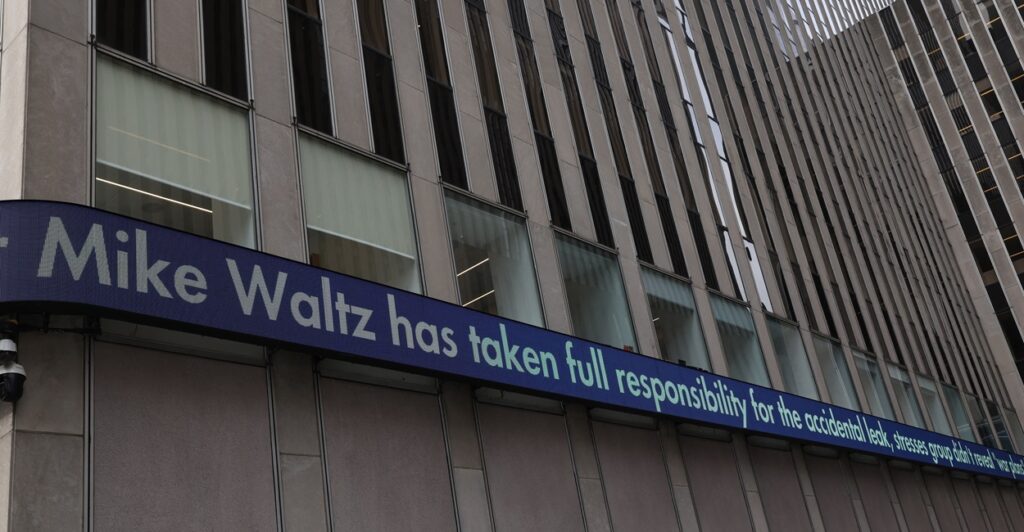 A Fox News ticker tape shows a headline about the leak in a group chat involving the Trump administration.