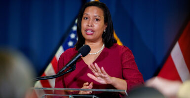 Muriel Bowser in a red blouse in front of American flags