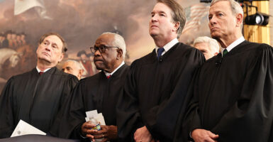 Justices Samuel Alito, Clarence Thomas, Brett Kavanaugh, and John Roberts stand in black robes.