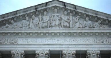 The front of the U.S. Supreme Court building is shown, focusing on the carved statues embedded into the wall.