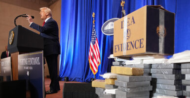 President Trump speaks in a suit near a large cache of DEA evidence of fentanyl