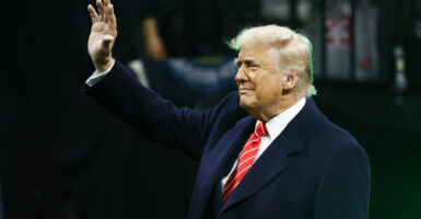 Donald Trump in a suit waves