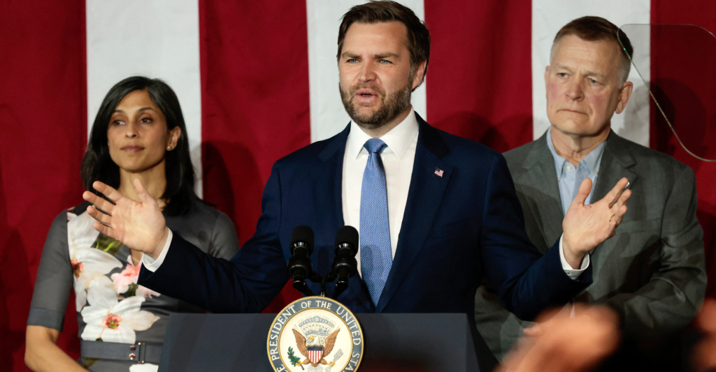 With an oversized American flag as his backdrop, Vice President JD Vance—flanked by wife Usha Vance and plant owner Paul Aultma—speaks at Vantage Plastics in Bay City, Michigan, on Friday. (Jeff Kowalsky/AFP via Getty Images)