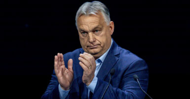 Viktor Orban claps in a blue suit