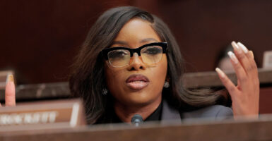 Representative Jasmine Crockett holds up her hands as she speaks at a House hearing
