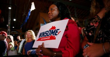 Trina Keeny holds up a political sign in support of Winsome Earle-Sears for governor.