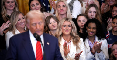 Donald Trump signs an executive order banning men from women's sports, while surrounded by female athletes on Feb. 5.