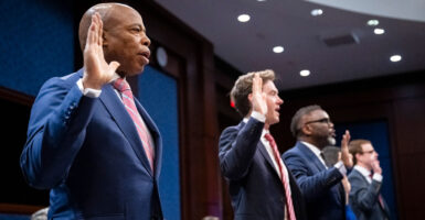 New York Mayor Eric Adams and other big city mayors being sworn in with their hands raised at a congressional hearing