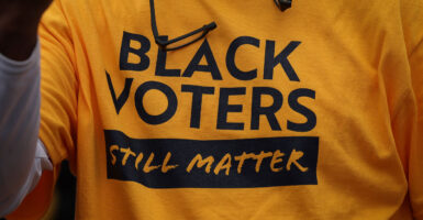 yellow T-shirt with black lettering that says black voters still matter