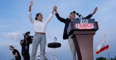 Rep. Alexandria Ocasio-Cortez, D-N.Y., and Sen. Bernie Sanders, I-Vt., wrap up a rally at Folsom Lake College's athletic track on April 15 by clasping hands above their heads.