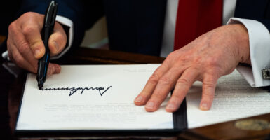 Close-up of President Trump's hands as he signs an executive order.