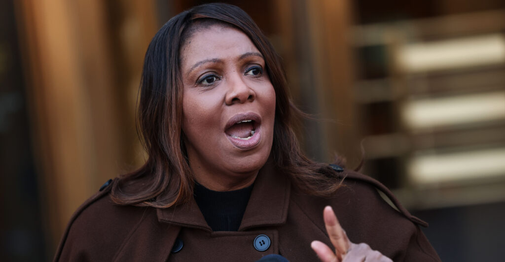New York Attorney General Letitia James in a brown overcoat speaking and gesturing outdoors in front of a microphone