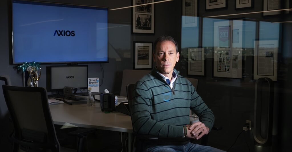 Jim VandeHei sits in a chair with his hands folded and in his lap as he poses for a portrait.