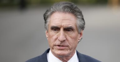Doug Burgum is standing and stares ahead as he talks to reporters at the White House.