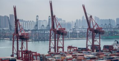 Shipping containers sit on the docks near cranes in Hong Kong.