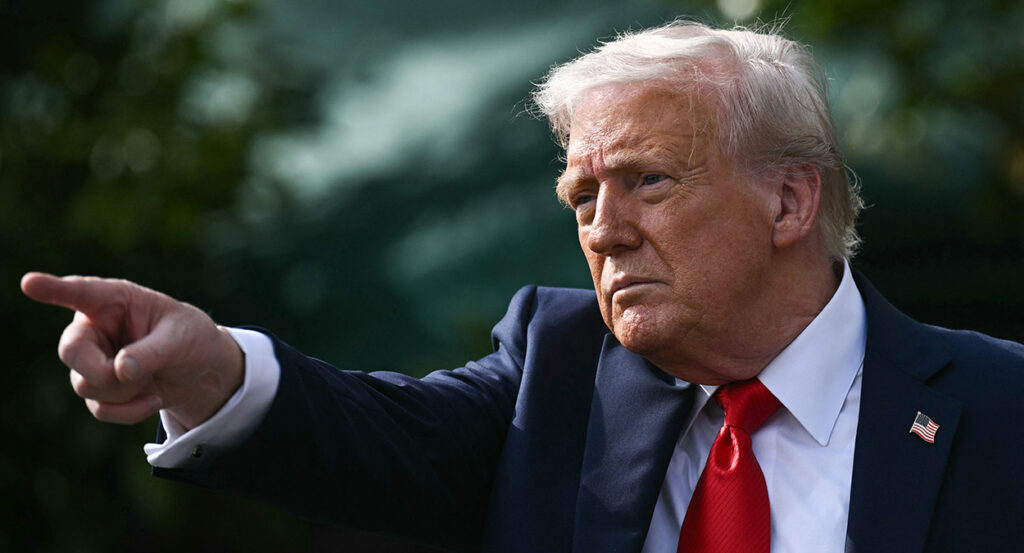 Donald Trump in a suit points off camera