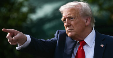 Donald Trump in a suit points off camera