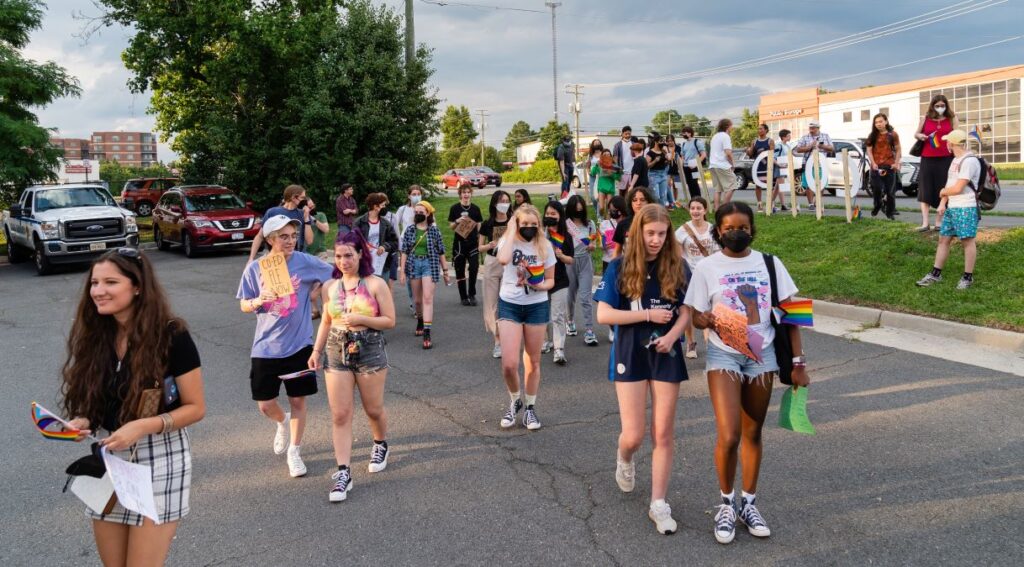 Students, mostly carrying Pride flags, march to a Fairfax County School Board meeting after a rally in support of inclusive Family Life Education outside of Luther Jackson Middle School in Falls Church, Va.