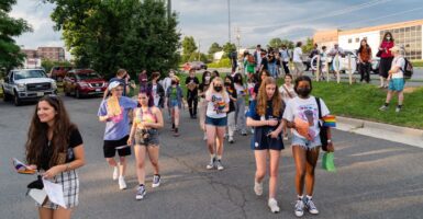 Students, mostly carrying Pride flags, march to a Fairfax County School Board meeting after a rally in support of inclusive Family Life Education outside of Luther Jackson Middle School in Falls Church, Va.