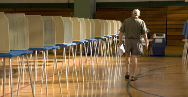 Solitary man walks past empty voting booths on way to cast his ballot.