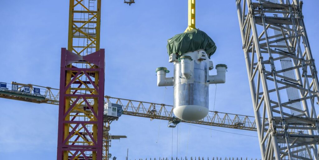 The silver pill-shaped core model of the world's first commercial small modular reactor is being lowered by a crane in Changiang, China.