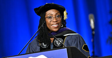 Ketanji Brown Jackson stands at a podium wearing academic regalia.