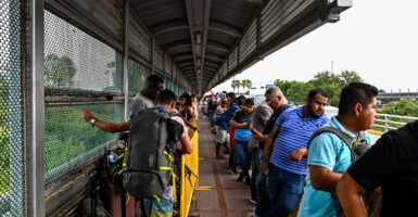 Migrants wait in line.