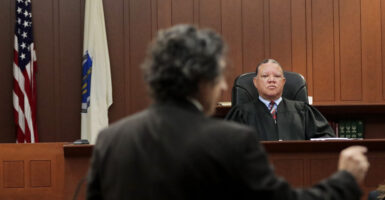Boston Municiple Court Judge Mark Summerville looks on stoically as an ICE defense lawyer gestures toward the prosecution and argues against holding an ICE agent for "obstructing justice."