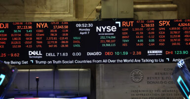 Digital display of New York Stock Exchange board early Monday, with assorted stock prices and news ticker on bottom of screen.
