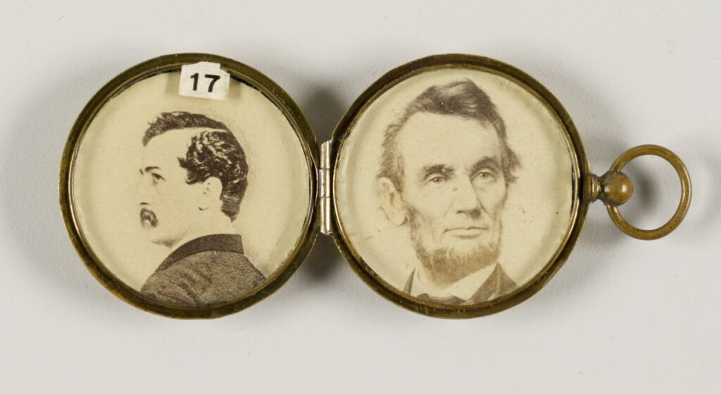 An antique gold locket contains a photo of President Abraham Lincoln and a photo of John Wilkes Booth.