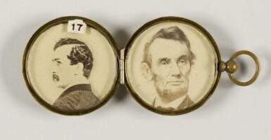 An antique gold locket contains a photo of President Abraham Lincoln and a photo of John Wilkes Booth.