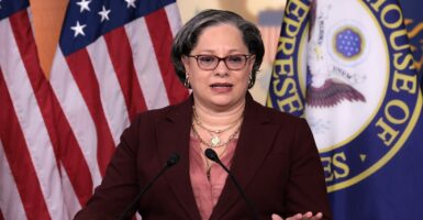 Jennifer McClellan stands in front of a podium and speaks while putting her left hand on the podium.