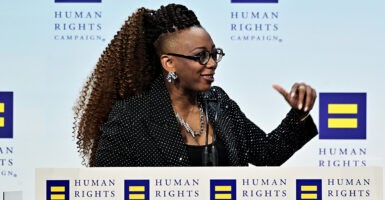 Human Rights Campaign President Kelley Robinson gestures while in a black suit coat with