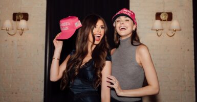 Two attendees at a MAGA event in Washington, D.C., pose for a photo while showing their MAGA hats.