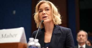 Katherine Maher sits at a desk with a microphone in front of her as she testifies.