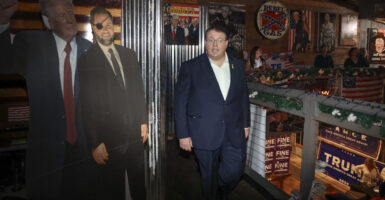 Randy Fine walks past cut-outs of President Donald Trump and Vice President J.D. Vance on his way to address media after winning Florida special election.