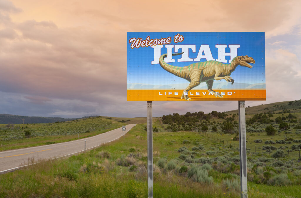 A sign by the side of a remote highway welcomes people to the state of Utah.