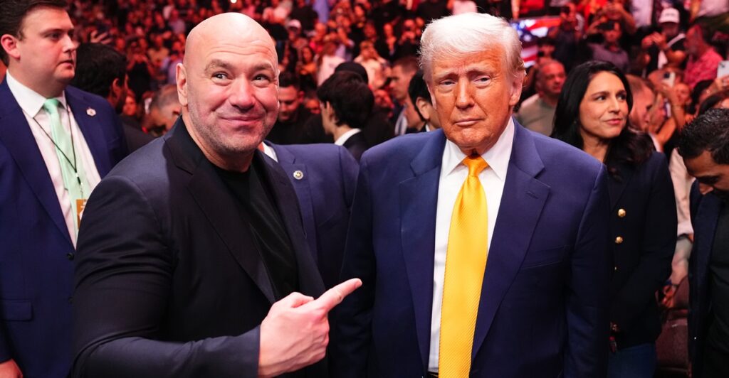 Dana White stands next to Donald Trump and points to Trump with his right hand.