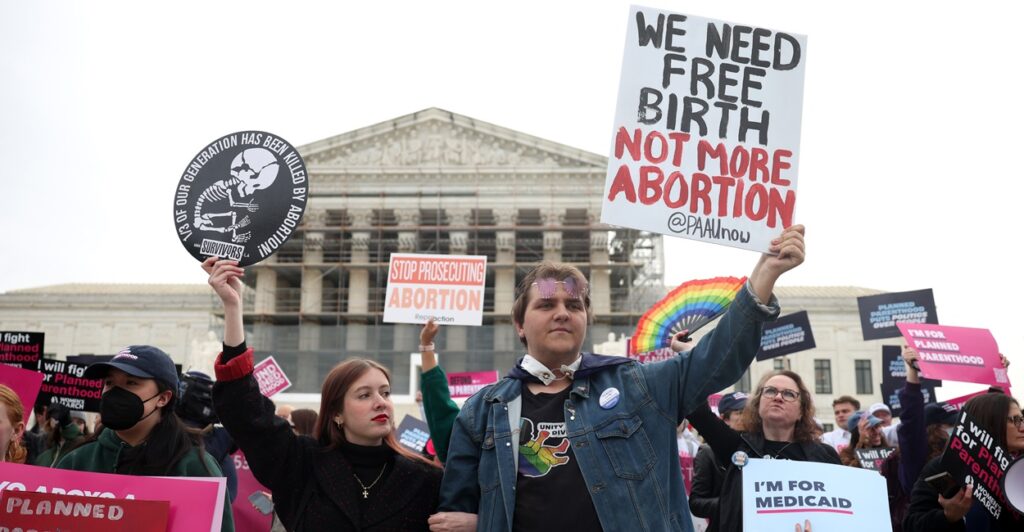 Pro life activists hold up signs as they attend a rally.