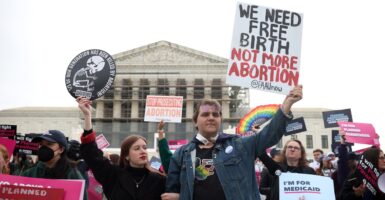 Pro life activists hold up signs as they attend a rally.