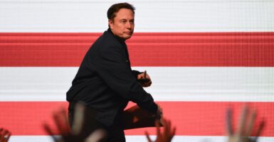 Elon Musk throws a signed cheesehead hat he was wearing into the crowd.